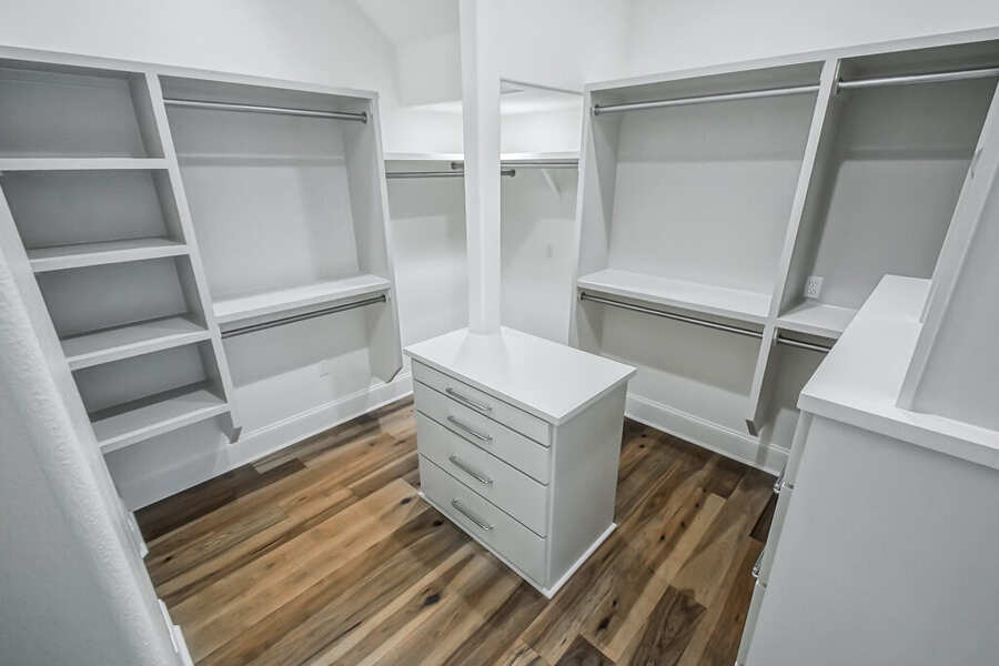 Custom primary closet with center island and built-in shelving