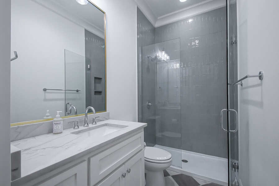 Guest bathroom with custom vanity and glass-enclosed shower