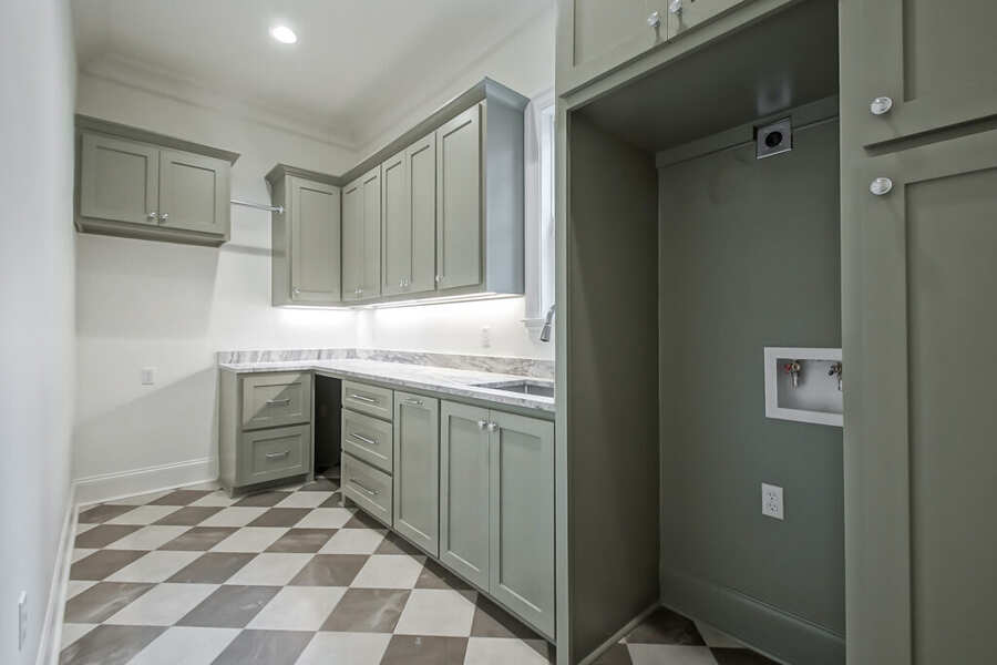 Custom laundry room with cabinetry and utility sink