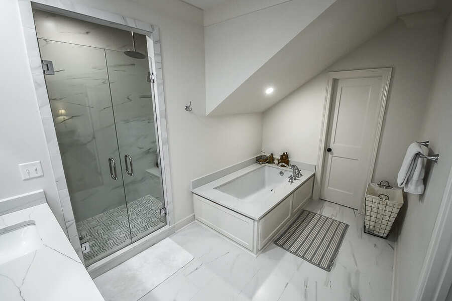 Spa primary bath addition with freestanding tub and large tile shower