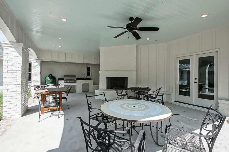 Covered outdoor living wing with masonry fireplace and haint-blue plank ceiling