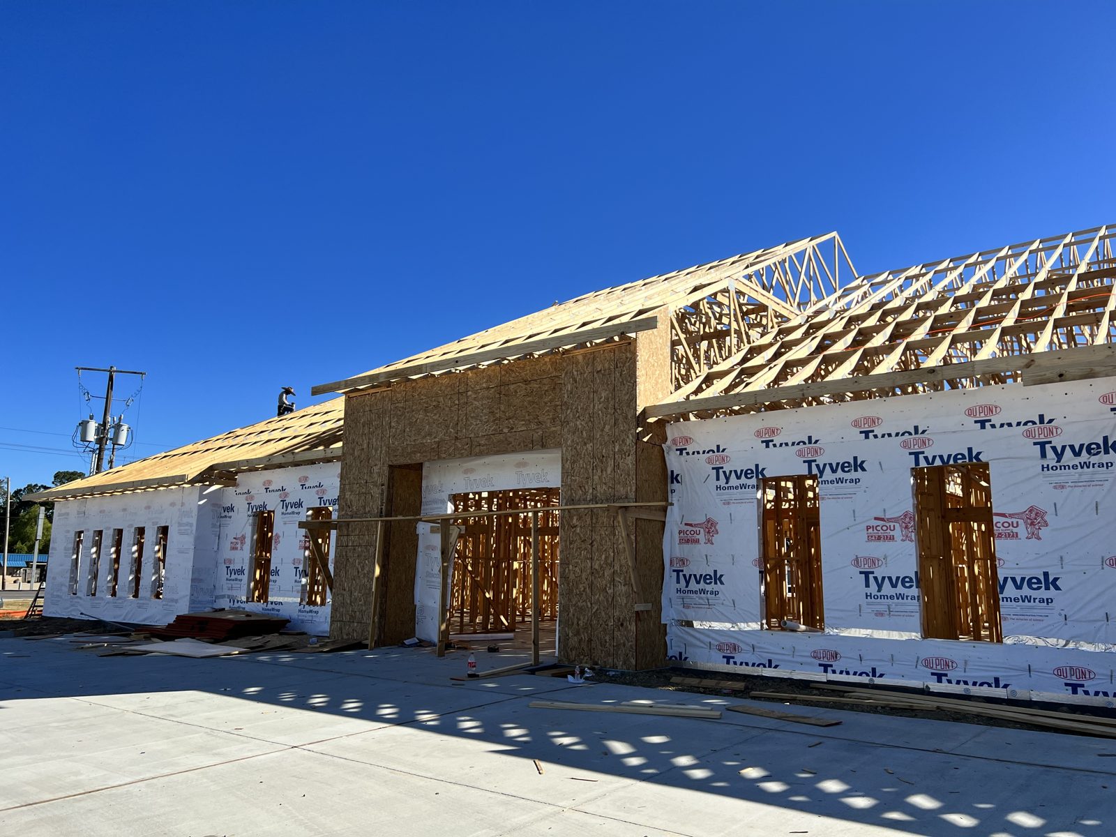 Commercial building framing and roof trusses against blue sky