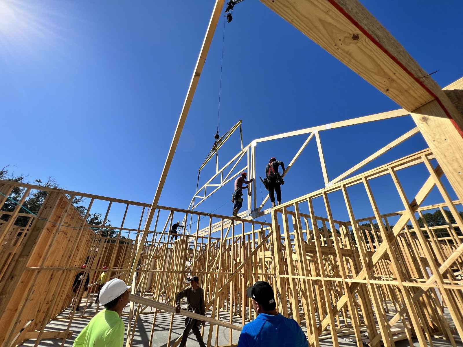 Interior view of commercial roof trusses being set by the crew