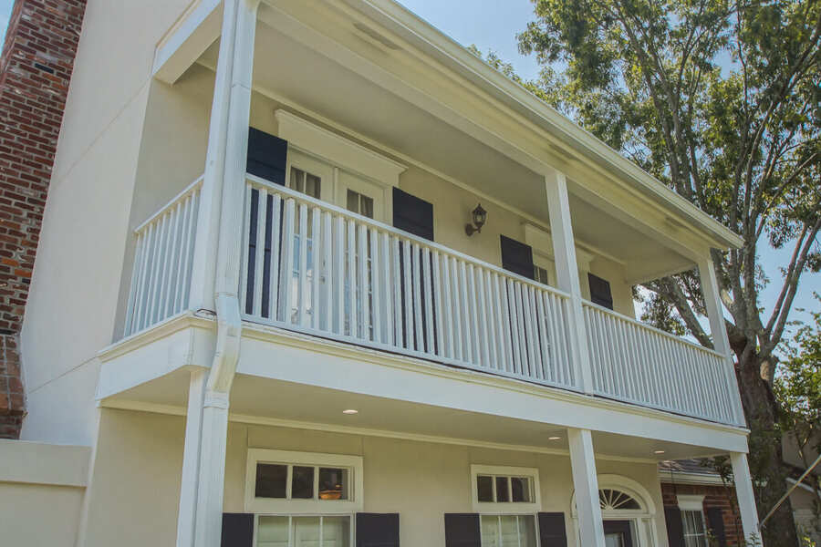 Second-floor covered balcony with painted railing