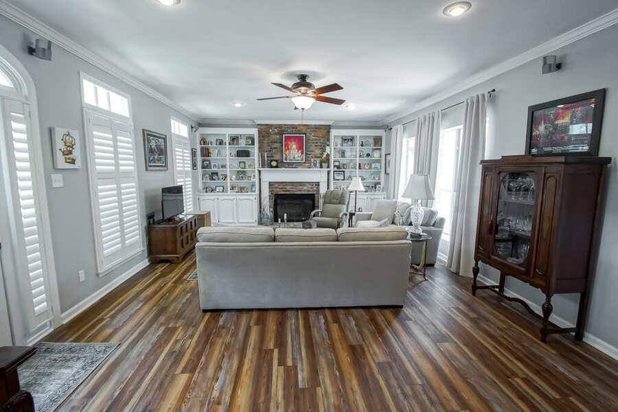 Living room with plantation shutters, built-ins and a brick fireplace