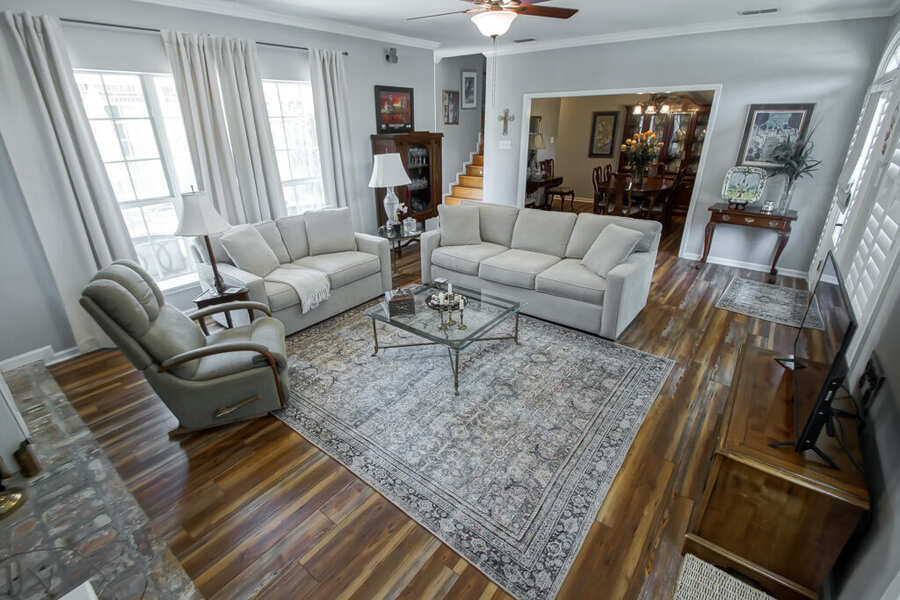 Formal living room with hardwood floors opening to the dining room
