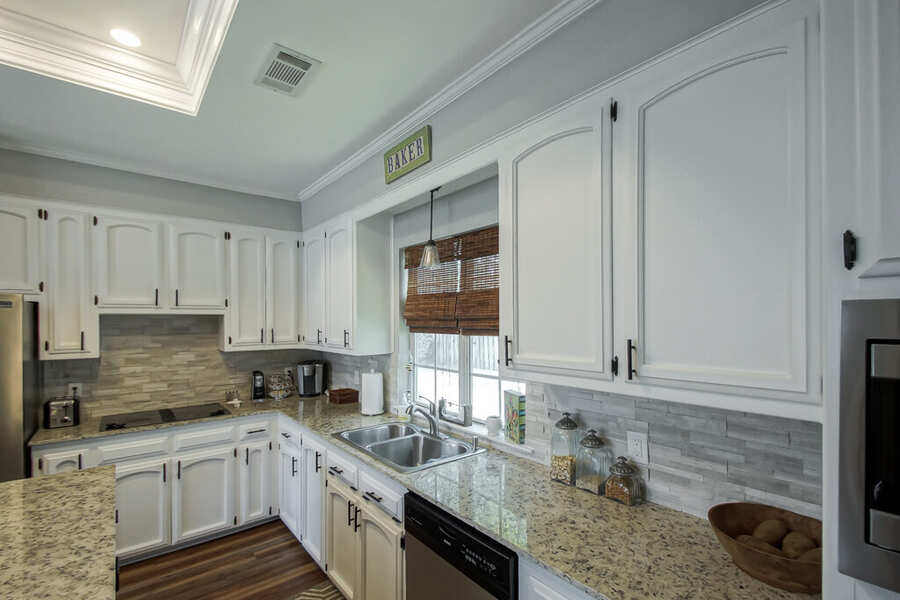Kitchen sink run with granite counters and tile backsplash
