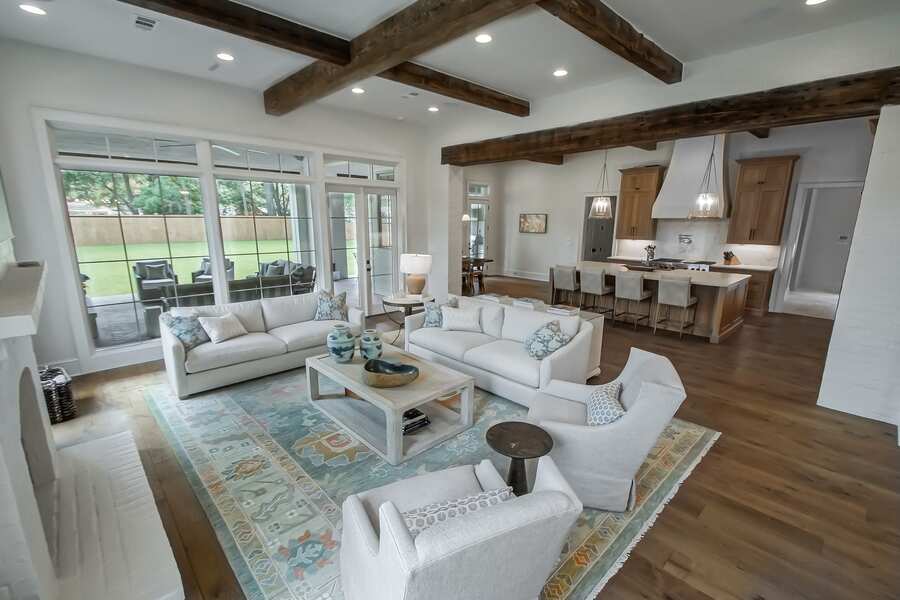 Open living room with reclaimed wood beams and stone fireplace