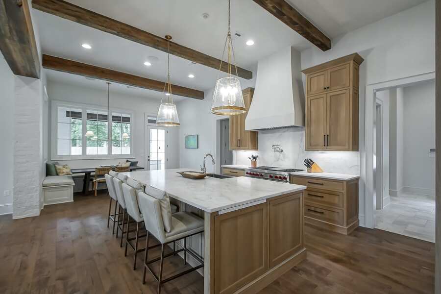 Custom kitchen with stained wood cabinetry and marble waterfall island