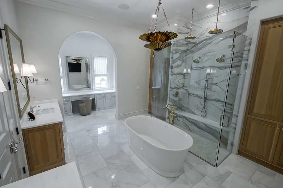 Spa-style primary bath with freestanding tub and marble shower