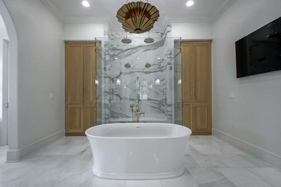 Walk-through marble shower with freestanding soaking tub
