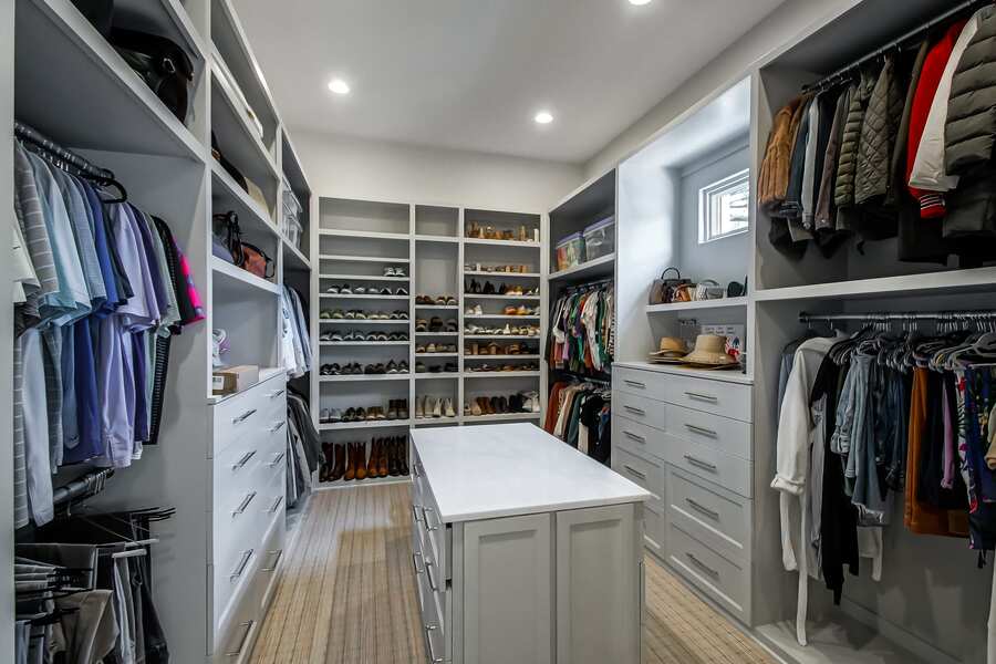 Custom walk-in closet with center island and built-in shelving