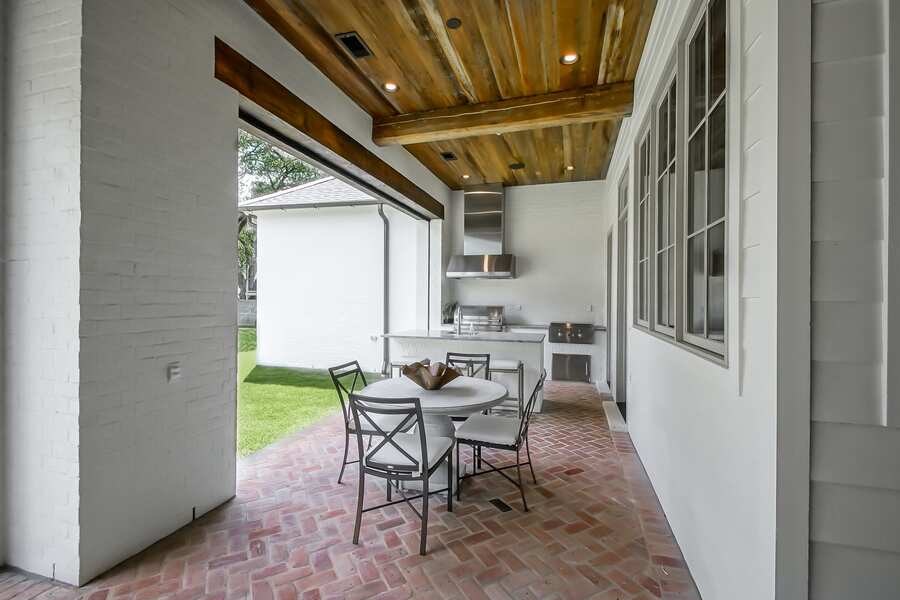 Outdoor kitchen with stainless grills on brick herringbone patio