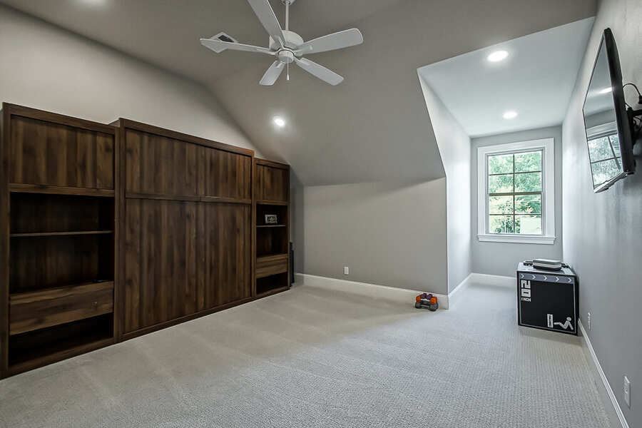 Guest bedroom with a built-in wood Murphy bed and vaulted ceiling