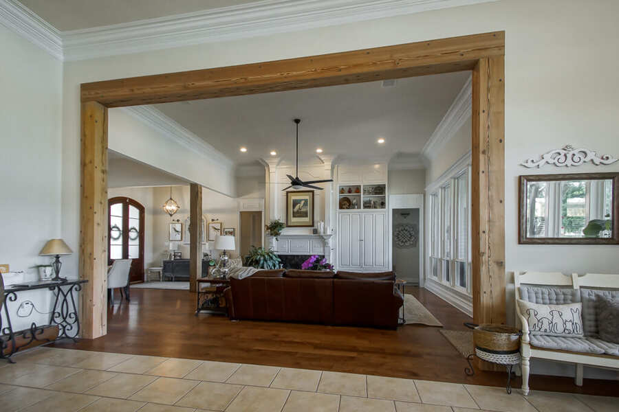 Wide beam-framed opening between the entry and the living room