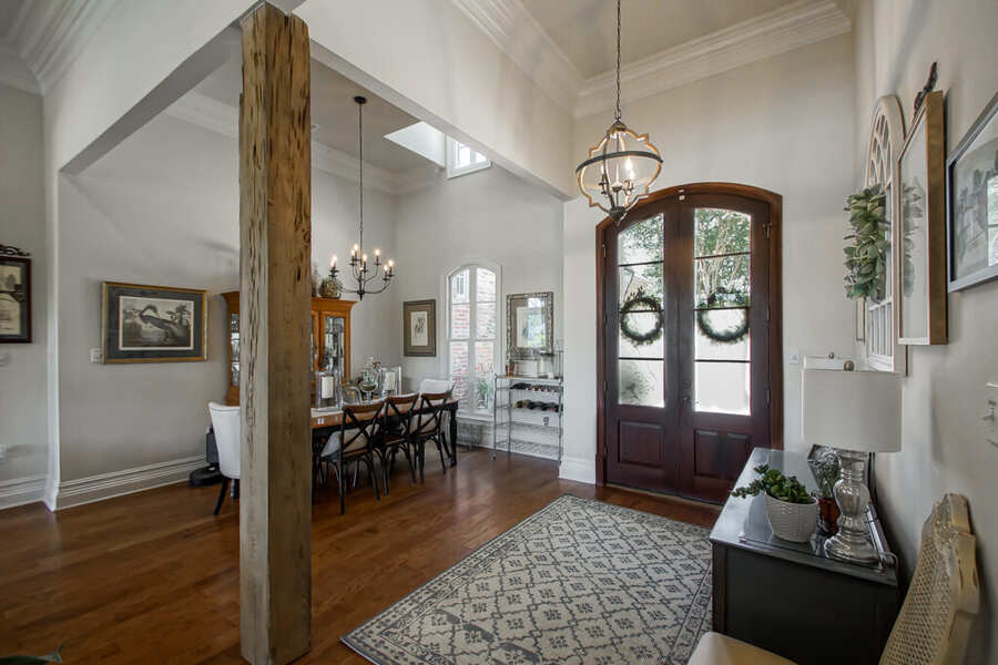 Reclaimed-cypress column with the dining room beyond the two-story entry