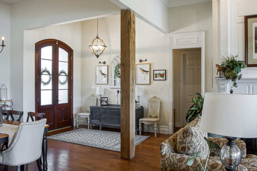 Foyer with a reclaimed-cypress post and arched front door