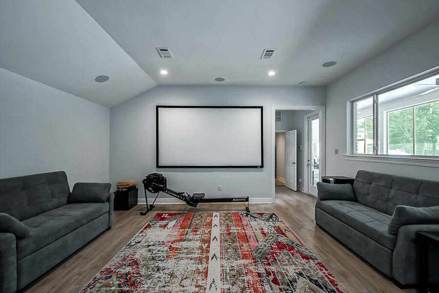 Media room with projection screen and vaulted ceiling