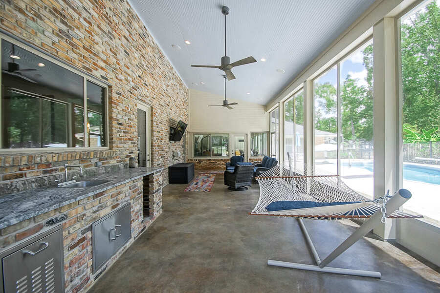 Screened porch with brick outdoor kitchen overlooking the pool