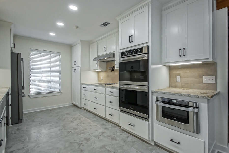 Built-in double wall ovens and microwave in white shaker cabinetry