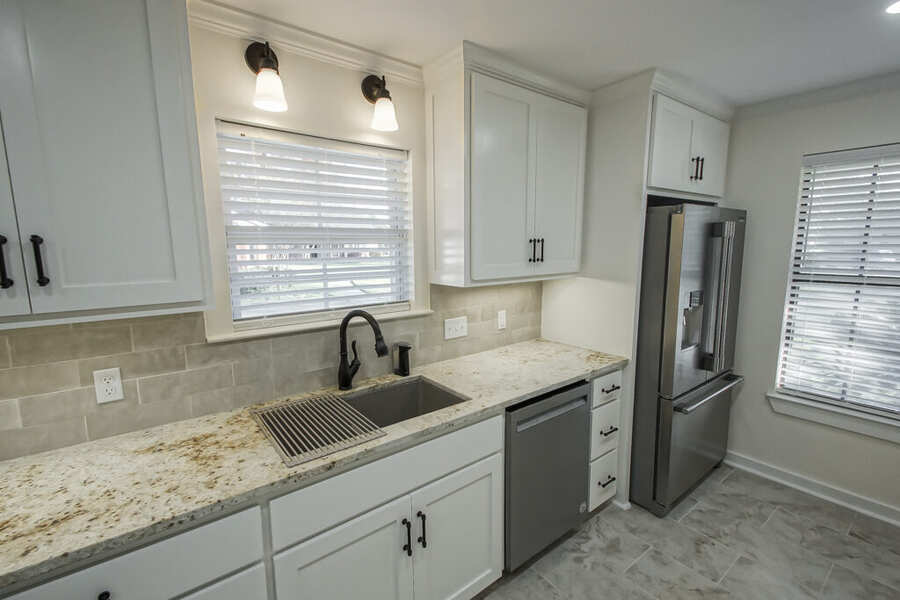 Undermount sink with a matte black faucet and granite countertop
