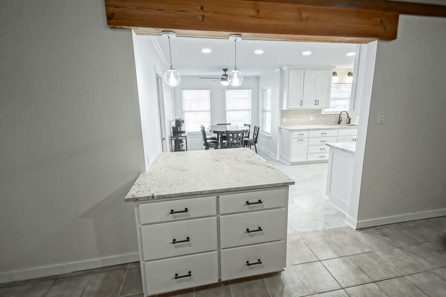 Kitchen peninsula with drawer storage beneath a reclaimed wood beam