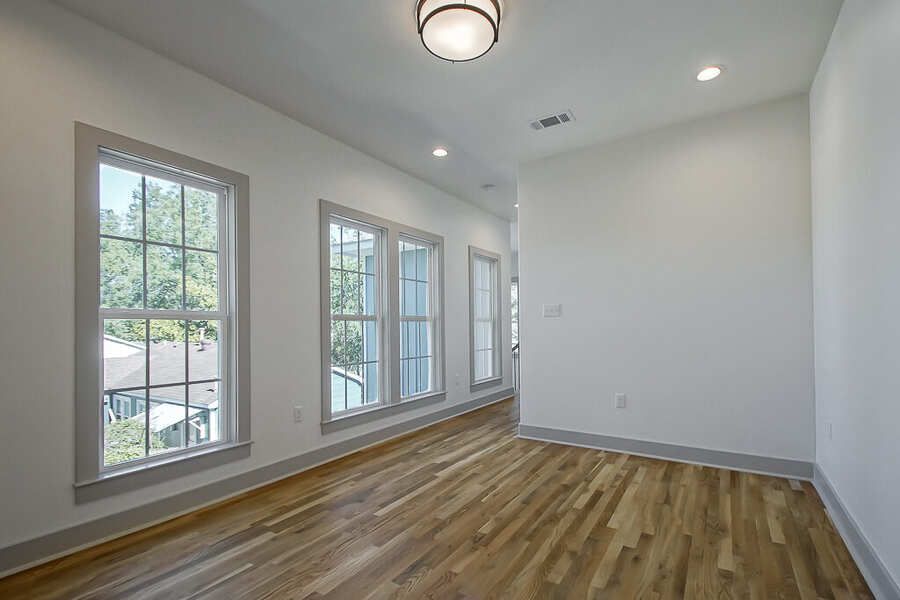 New open bonus area with a wall of windows and wood flooring