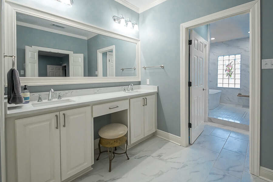 Dual vanity with a center makeup station and framed mirrors