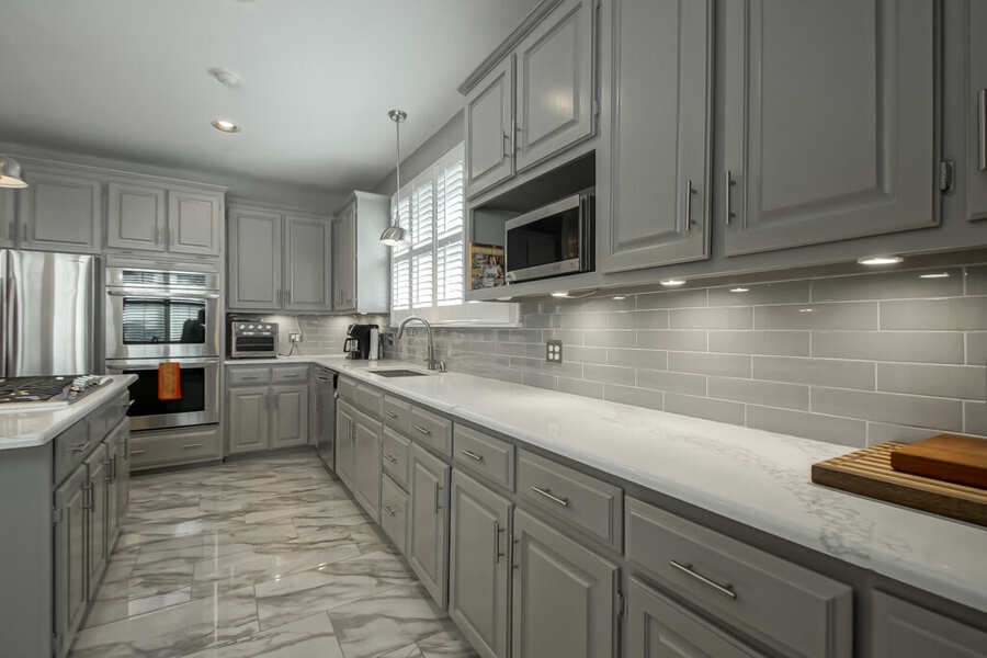 Perimeter cabinetry run with subway tile backsplash and quartz counters