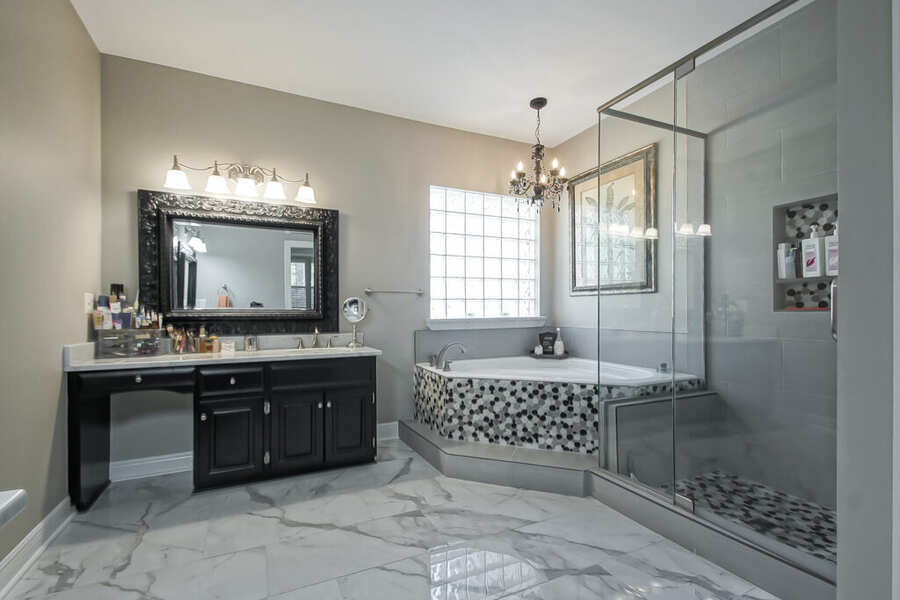 Primary bath with corner soaking tub and glass-enclosed shower