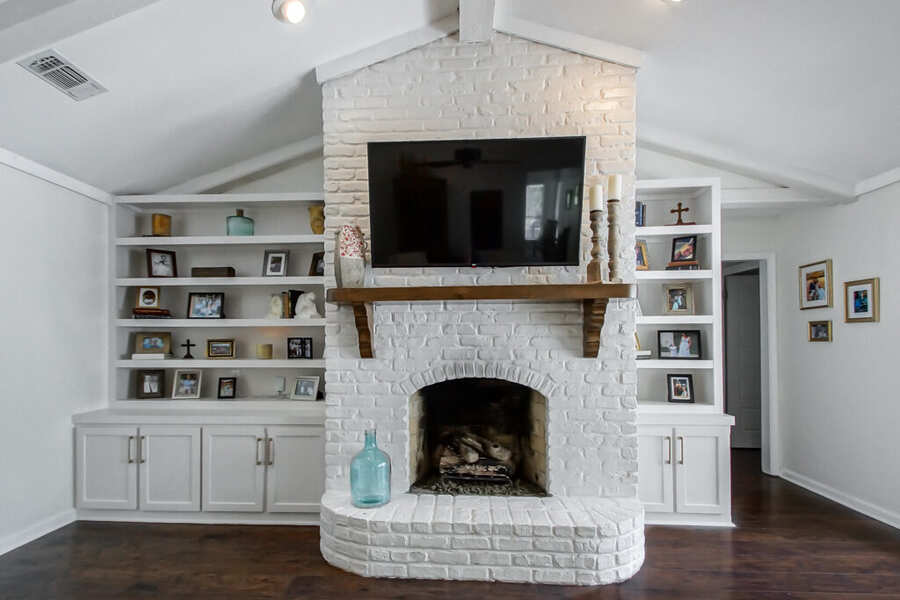 Painted white-brick fireplace with new built-in shelving and cabinets